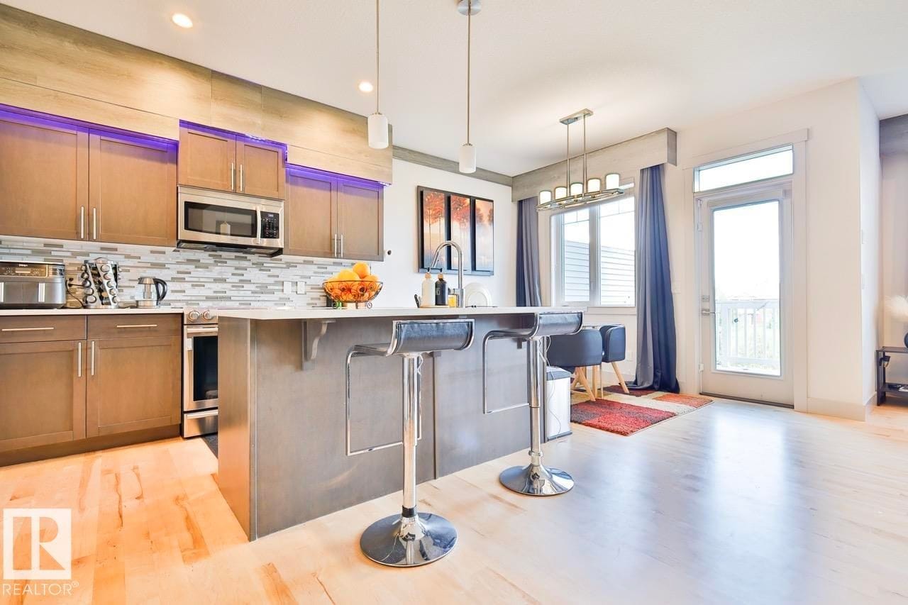 Kitchen with tile backsplash and pendant lighting